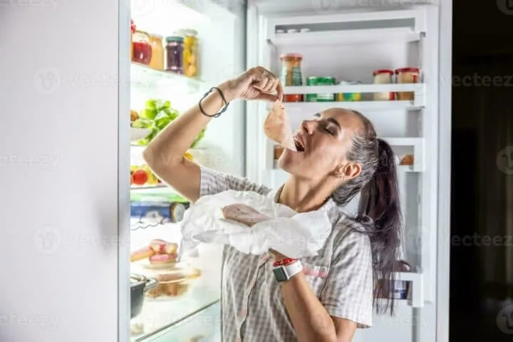 hungry woman enjoying ham at night